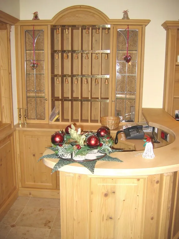 Runde Rezeptionstheke aus Holz vor einem Schrank mit Schlüsselfächern