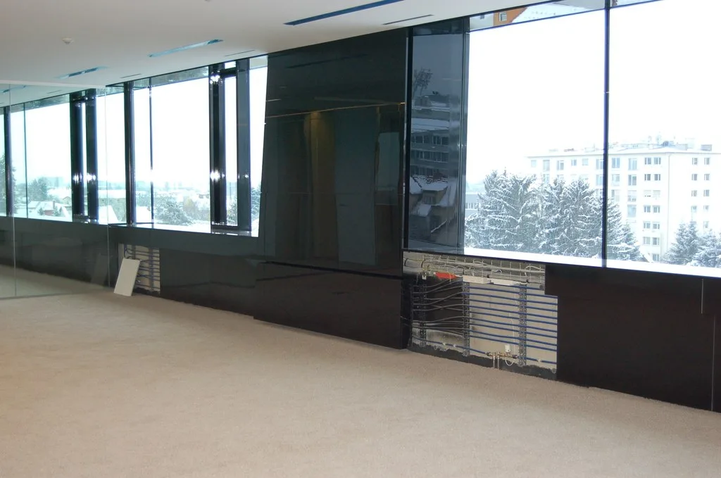 Großraum mit schwarzen Glasverkleidungen vor einer Fensterfront im Winter